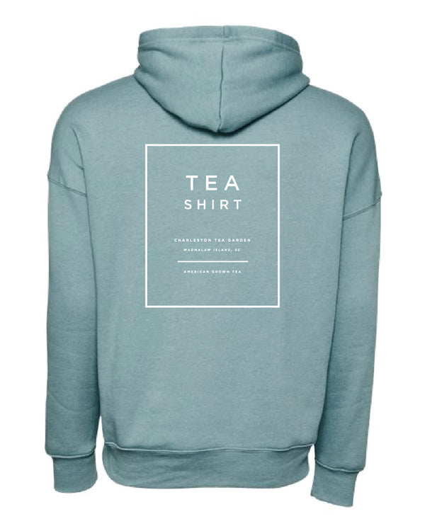 Back view of a soft blue fleece hoodie with a simple white "TEA SHIRT" design and Charleston Tea Garden branding, perfect for comfortable, casual wear.