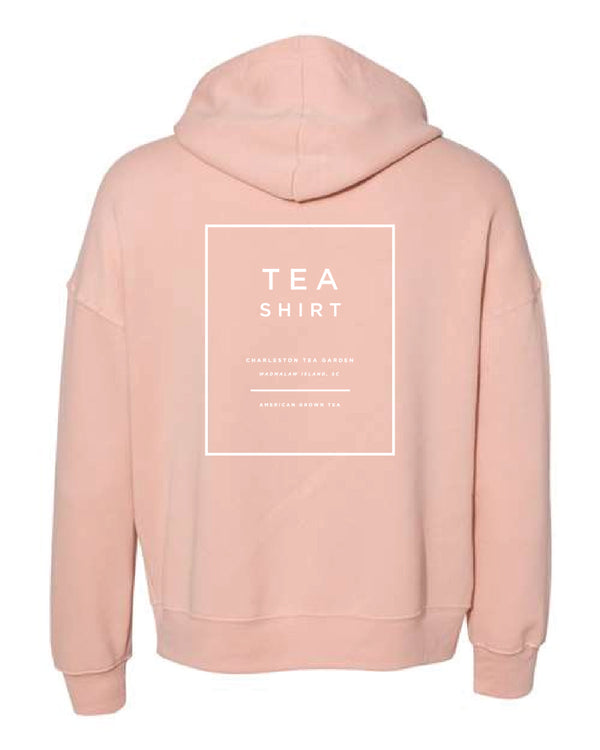 Back view of a soft peach-colored fleece hoodie featuring a minimalist white print promoting Charleston Tea Garden with a cozy, casual style perfect for everyday wear.