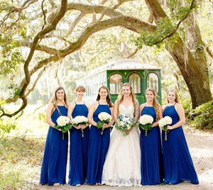 A photo of a bridal party in front of a trolley at Charleston Tea Garden in Charleston.