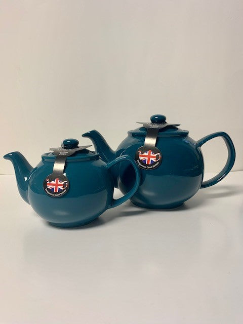 Two teal ceramic teapots, one smaller and one larger, displayed side by side against a plain background.