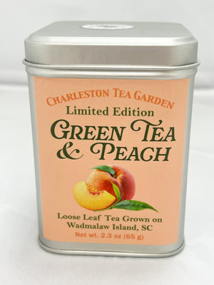 Silver Charleston Tea Garden tin labeled Limited Edition Green Tea and Peach, featuring illustrations of ripe peaches and green leaves on a peach colored label.