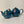 Two teal ceramic teapots, one smaller and one larger, displayed side by side against a plain background.